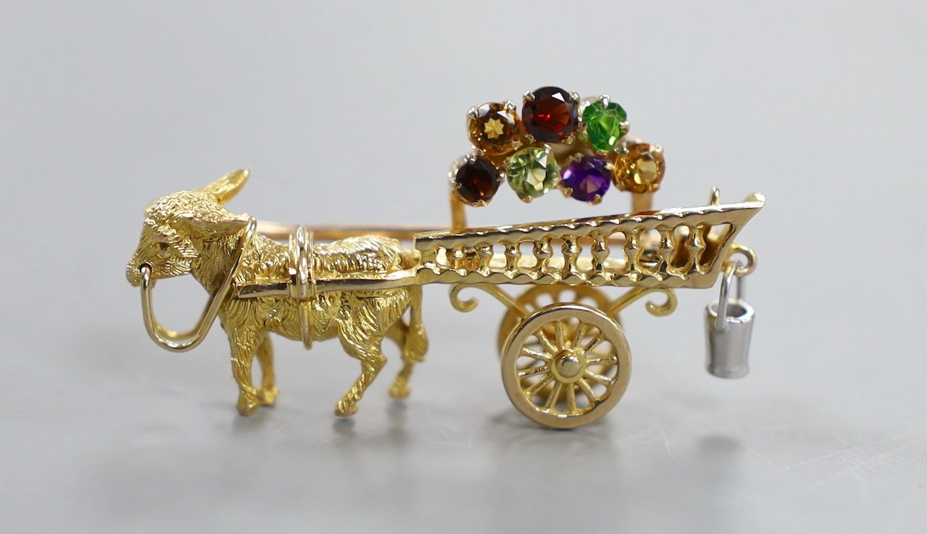 A modern yellow metal hinged bangle with Greek Key decoration and a 9ct donkey and cart charm, gross weight 23.2 grams.